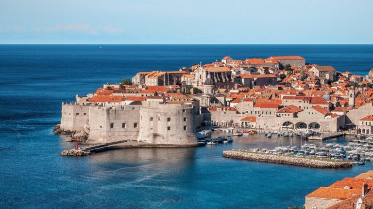 Staré město Dubrovníku s pevnostními hradbami a oranžovými střechami nad modrým Jaderským mořem