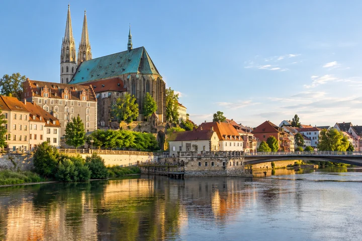 Kostel se dvěma věžemi a domy u řeky v Görlitz.