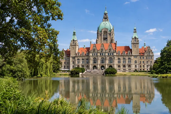 Monumentální budova s kupolí odrážející se na vodní hladině.