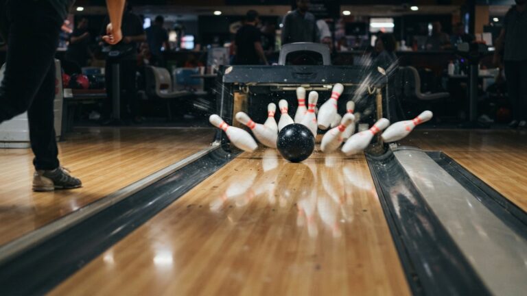 Bowlingová koule sráží kuželky na dráze