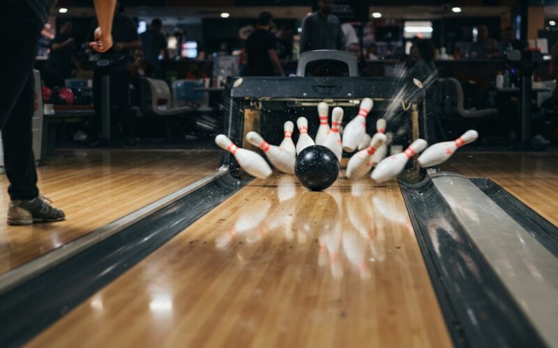 Bowlingová koule sráží kuželky na dráze