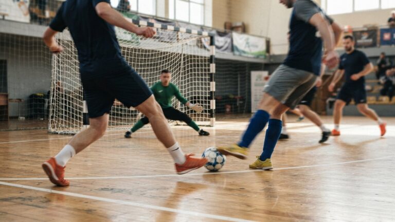 Futsalový míč na palubovce sportovní haly u branky